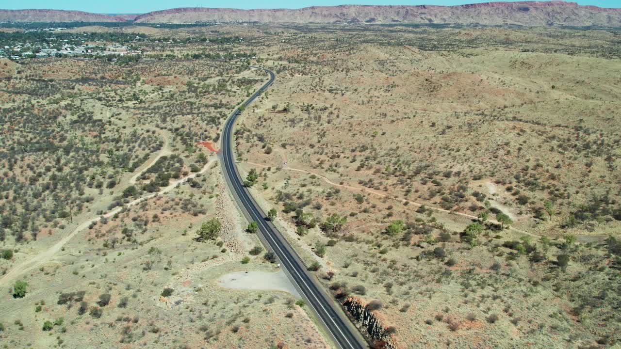 Aerial view looking south along the Stuart Highway at Irlpme, with Alice Springs, Mparntwe, in the distance. Northern Territory, Australia. August 2022.