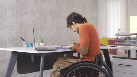 Joyful-disabled-businessman-works-at-home-with-laptop-and-earns.