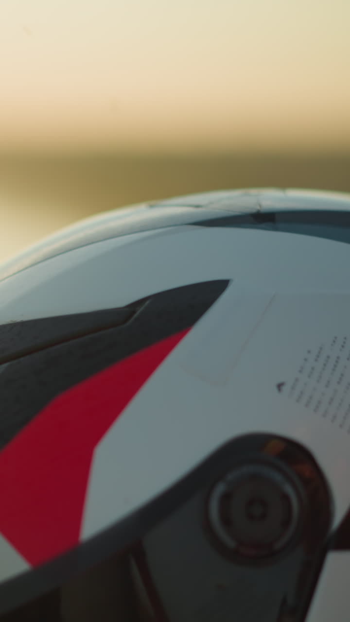 A close-up of a hand wearing a green bracelet, gently cleaning a motorcycle helmet