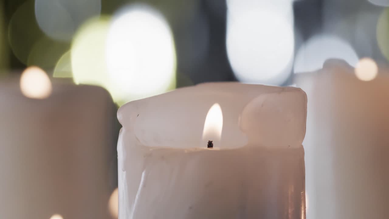 Video di candele bianche con fiamme bianche e spazio per il testo con effetto bokeh su sfondo nero