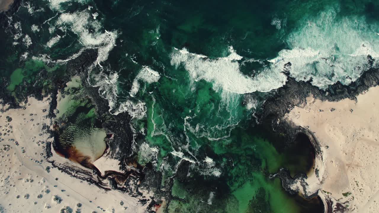 Toma aérea con dron de texturas naturales formadas por la marea en pozas intermareales.