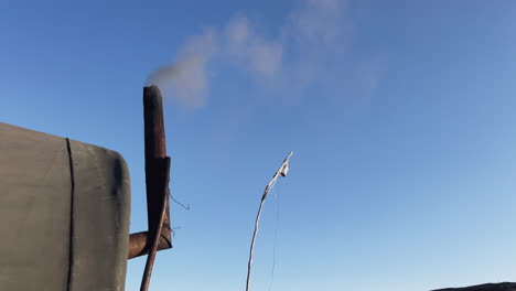 smoke rising from a stove chimney, heater used in a tent, wildlife, gray smoke image