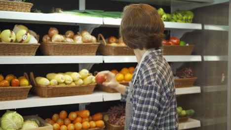 grocery store employee working in produce section