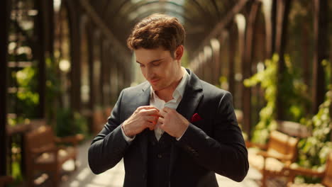 smiling man looking at camera in park. groom preparing for wedding ceremony