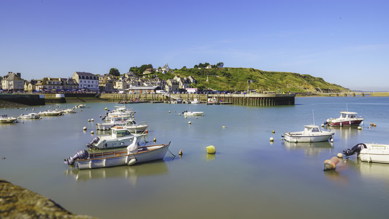 View over the harbour, in the middle of the day. The boats begin to bob slowly as the tide rises.