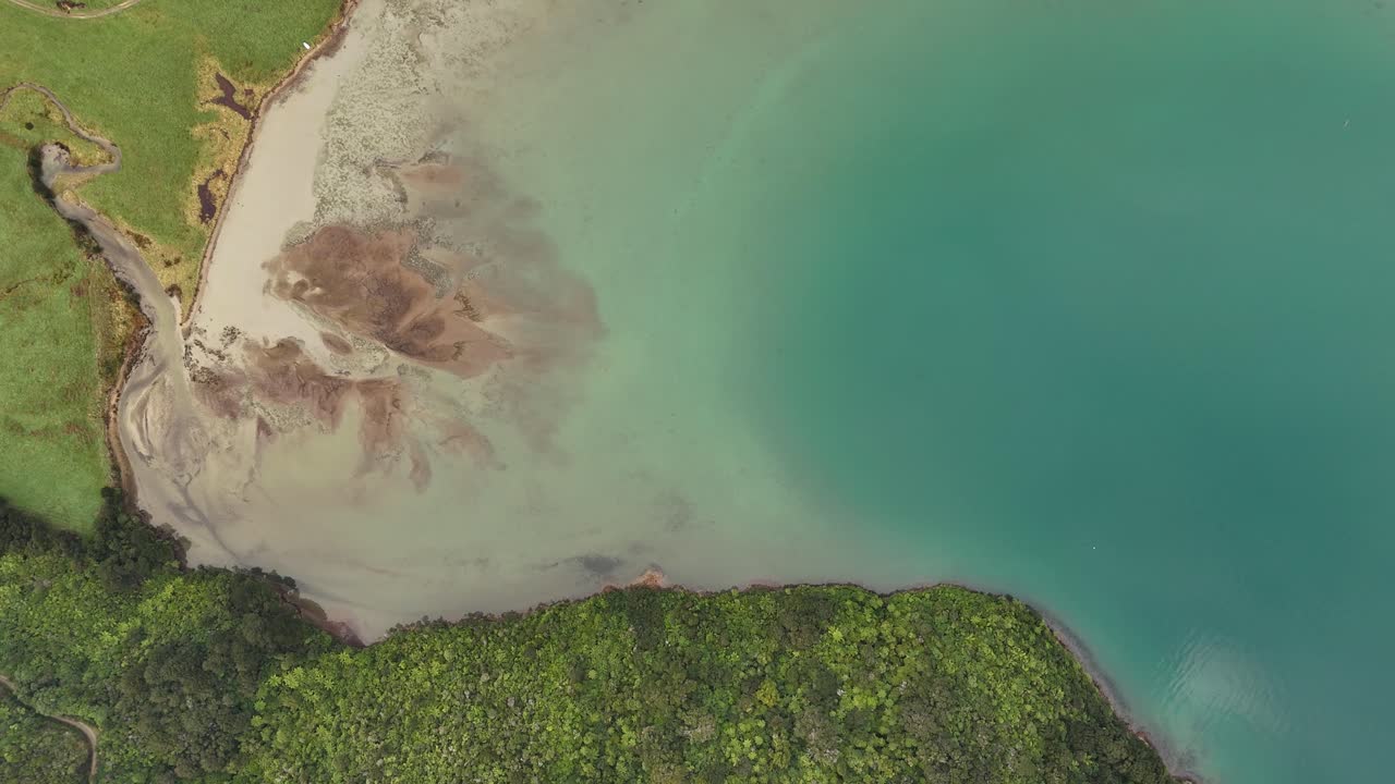 Breathtaking 4K drone footage captures a stunning top-down view of the serene shoreline in the Picton area of New Zealand's South Island, showcasing the intricate coastal patterns