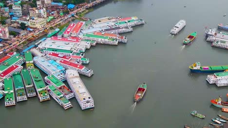 multiple ferries docked at terminal alongside busy city riverbank