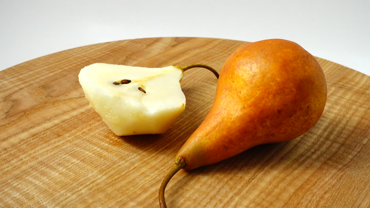 Pere su un tagliere di legno in cucina. Ripresa in movimento
