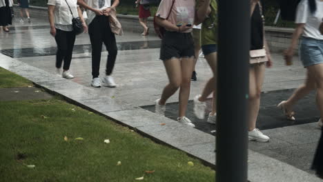 people walking on a wet pavement on a rainy, foggy day