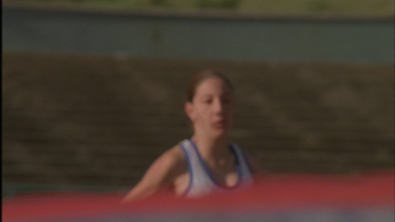una chica hace un salto de altura sobre una barra