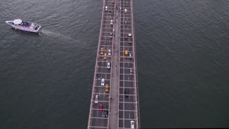 aerial view above the busy brooklyn bridge, revealing manhattan skyline, dusk in nyc, usa - tilt, drone shot