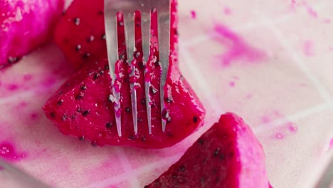 picando la deliciosa fruta del dragón rojo con un tenedor