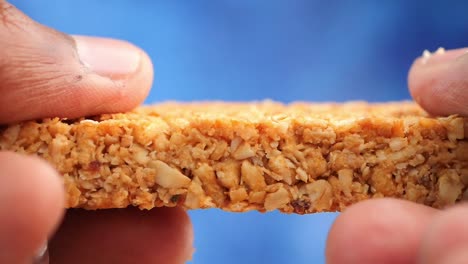 close-up of a cereal bar held by fingers