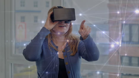 animation of network of connections over caucasian woman wearing vr headset