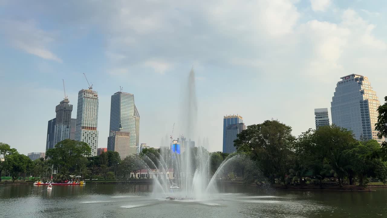 Lumphini Bangkok Thailand park green space water pond, city buildings skyline