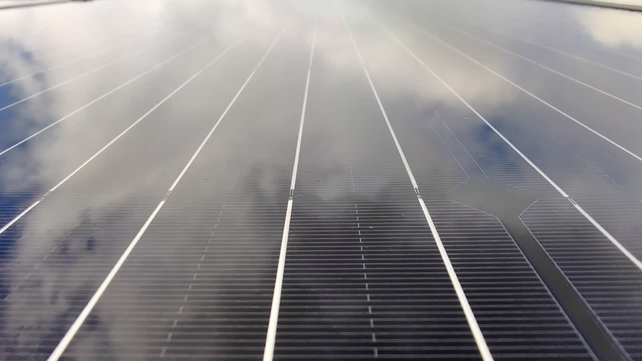 Wet silicon circuit solar panel - Handheld closeup moving along surface of solar panel with beautiful sky reflections
