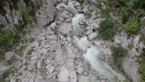 Video-of-a-flat-drone-seen-as-a-bird-advancing-over-the-river-of-the-Boka-house-with-crystal-clear-and-turquoise-waters-in-Slovenia