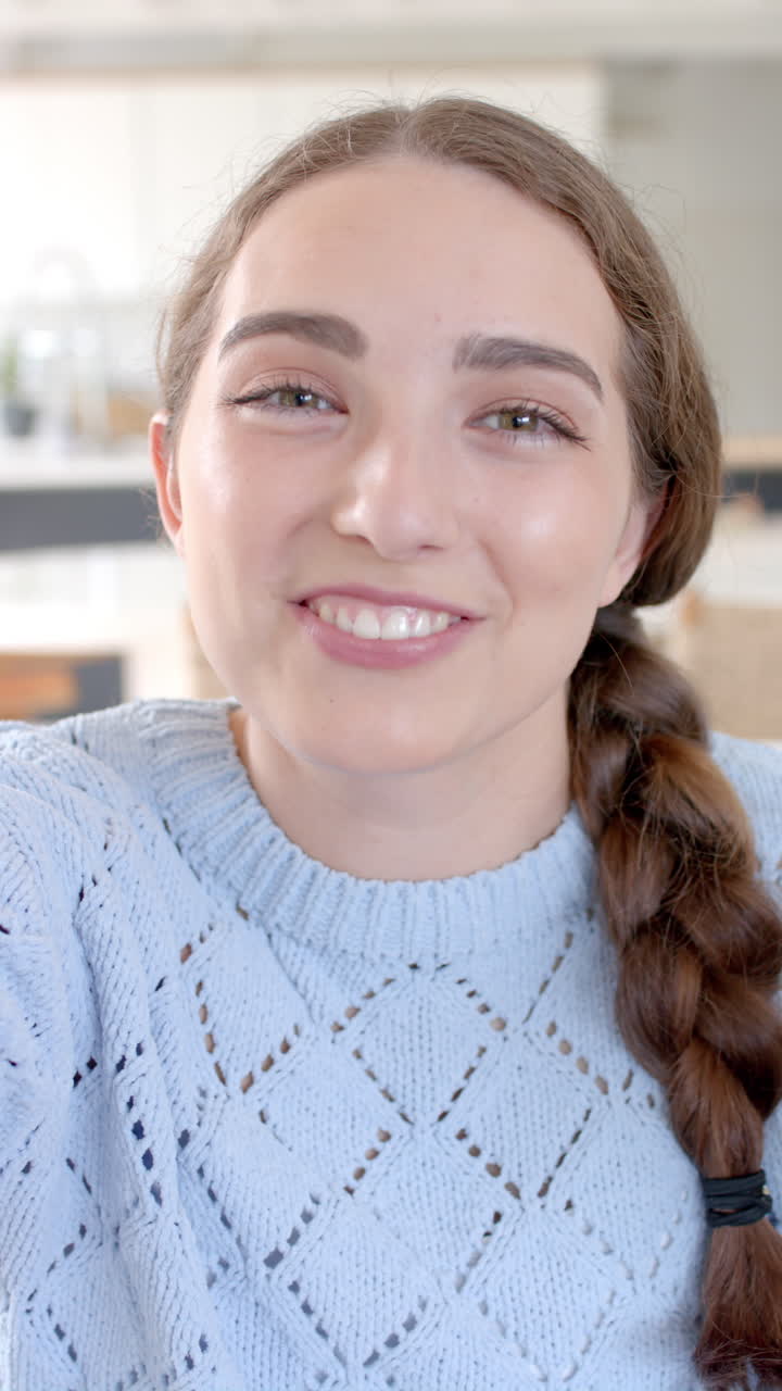 Vertical video of portrait of happy caucasian woman having video call in slow motion
