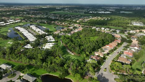Luxury homes and villas in well-kept district of town in Florida. Aerial op down. Sunset time in the evening. Private lake in garden