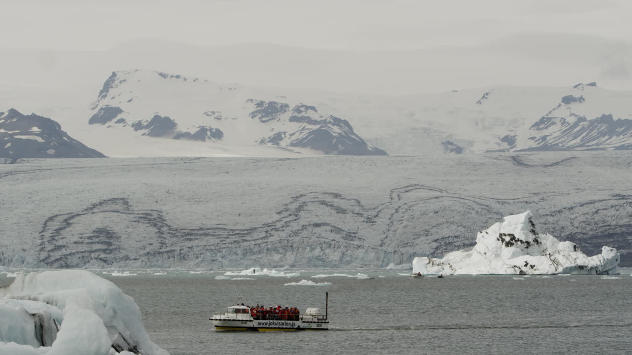 수륙 양용 빙하 석호 보트가 관광객을 아이슬란드의 요쿨살론 석호 주변 관광 여행으로 안내합니다.