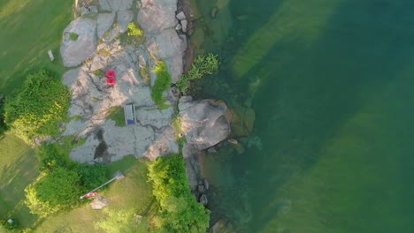 Aerial-slow-rotating-rocket-shot-of-the-young-women-enjoying-a-summer-day-on-a-clear-water-lake