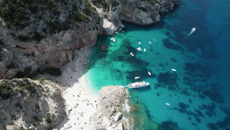 aerial top down drone video of tropical paradise turquoise coast in the mediterranean, sardinia with boats