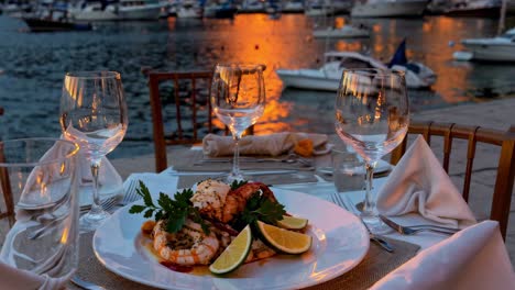 creating a romantic sunset dinner featuring a seafood platter, wine glasses, and an elegant table setting by the sea, offering an idyllic and luxurious dining experience