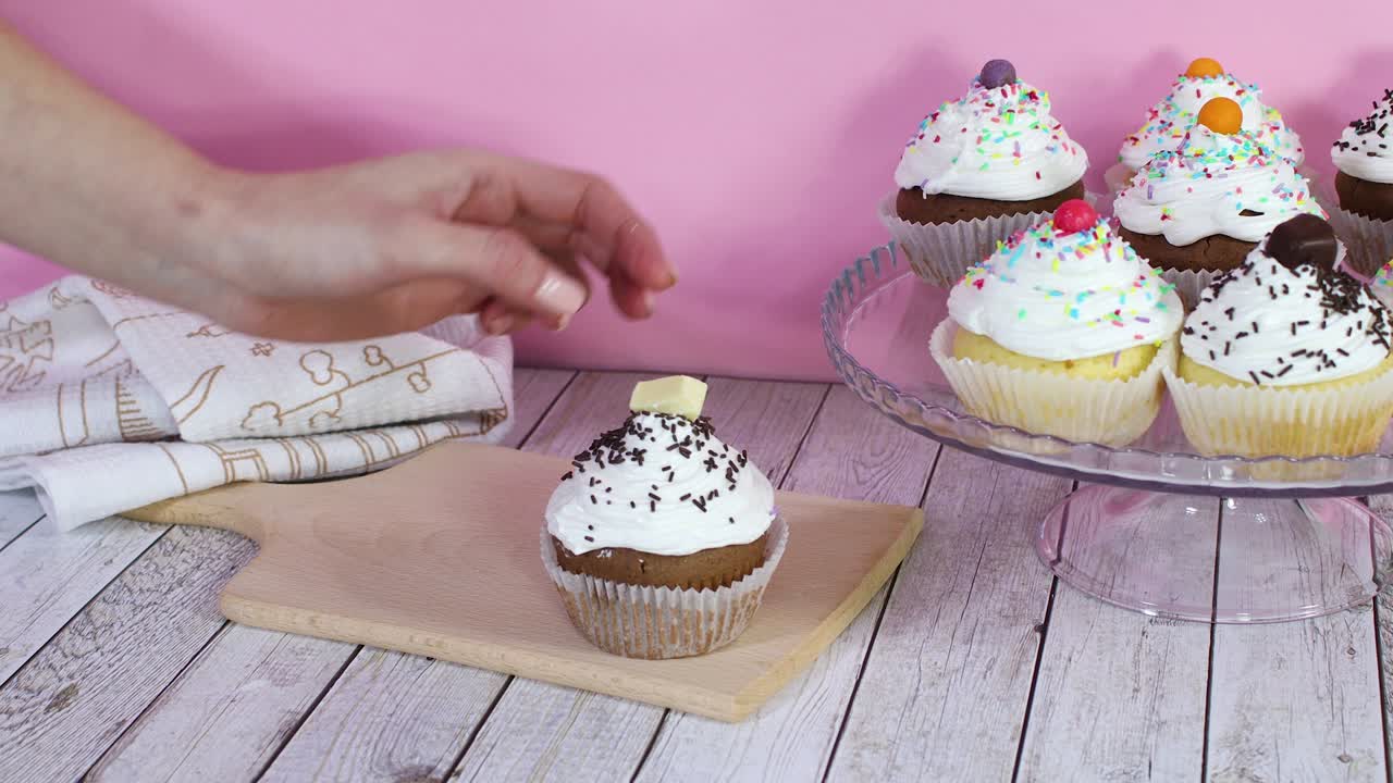 Posizionamento di deliziosi cupcake dal piatto sul tagliere