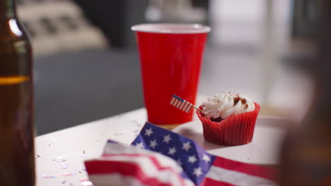 Primer-Plano-De-Cupcakes,-Banderas-Estadounidenses-Con-Estrellas-Y-Rayas-Y-Botellas-De-Cerveza-En-Una-Fiesta-Que-Celebra-El-4-De-Julio,-Día-De-La-Independencia.