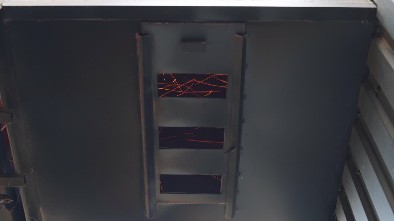 Metal construction grill of the dryer with bright fiery sparks that move quickly. Close-up of elevator details
