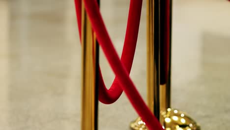 velvet red luxury ropes closed at valuable exhibit in museum or vip zone concert