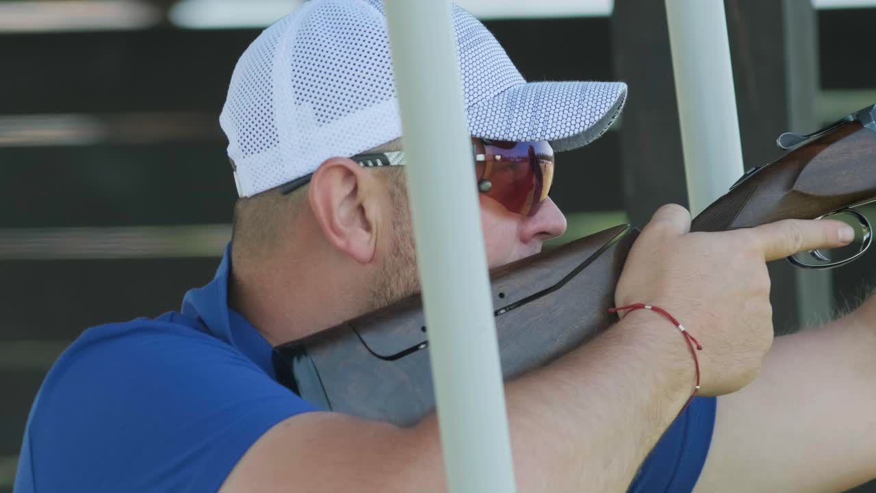 un deportista dispara con una escopeta de doble cañón, un campo deportivo para una prueba de tiro está disparando a un esquete volador