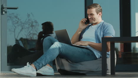 handsome business trader talking phone. freelancer working laptop computer