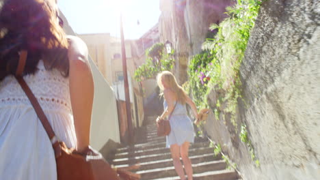 two women walking up stairs in a european town