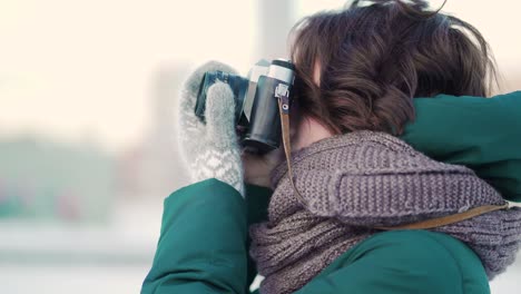 mujer tomando fotos en la ciudad de invierno