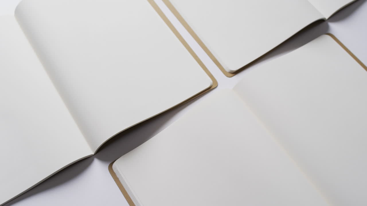 Close up of open blank books with copy space on white background in slow motion