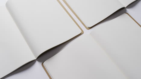 close up de libros en blanco abiertos con espacio de copia en fondo blanco en cámara lenta
