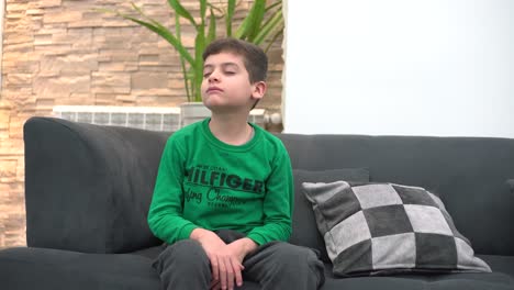 a child tired in front of the tv he falls asleep on the sofa