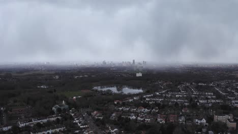 ariel shot of a misty london city over a small lake