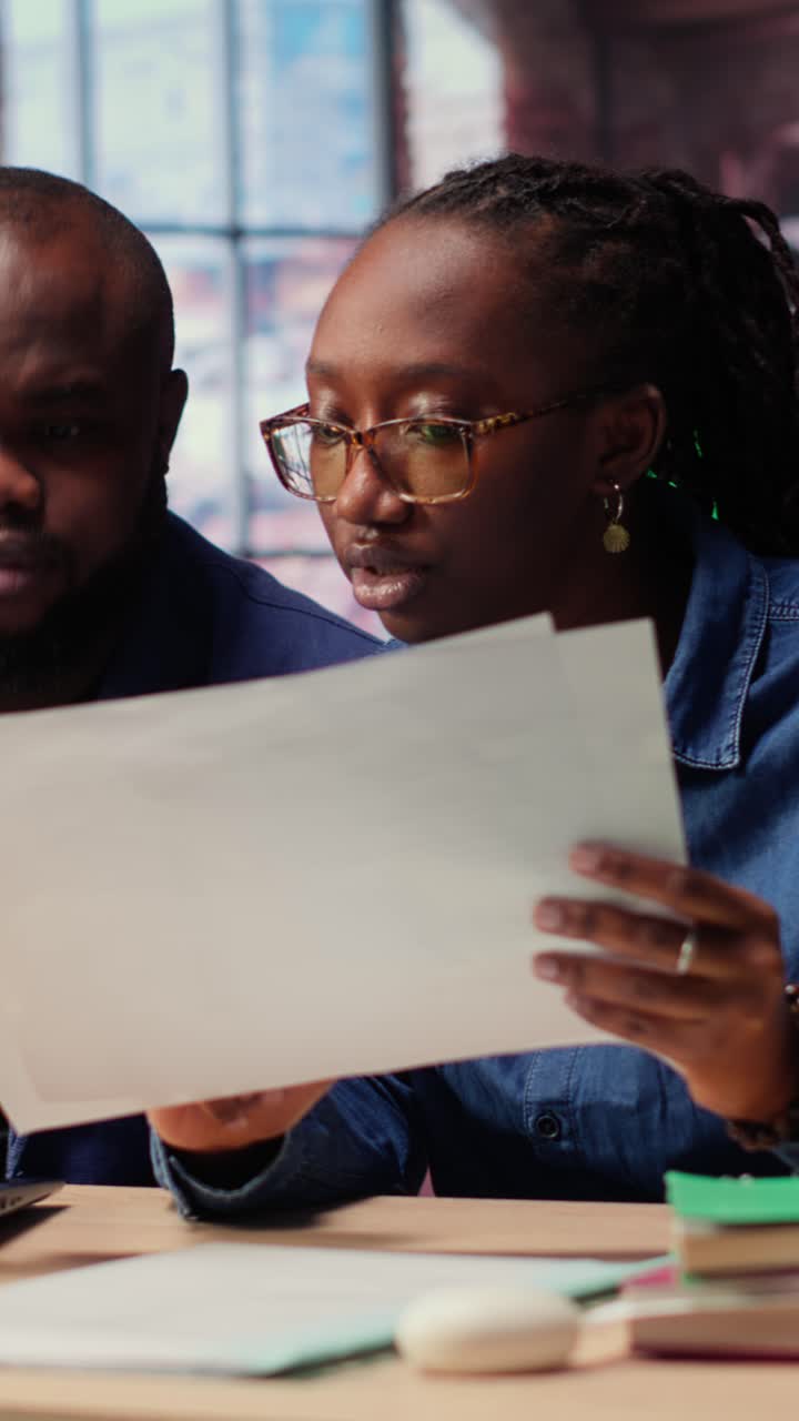 African American Business Colleagues Discussing Documents in Modern Office