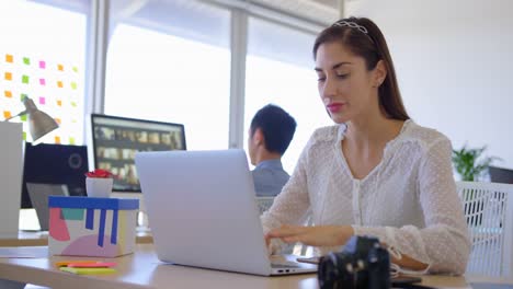 hermosa ejecutiva caucásica trabajando en una computadora portátil en el escritorio 4k