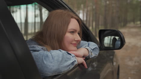 Red-Haired-Female-Enjoys-A-Drive-Through-The-Countryside-From-The-Window-Of-The-Car-1