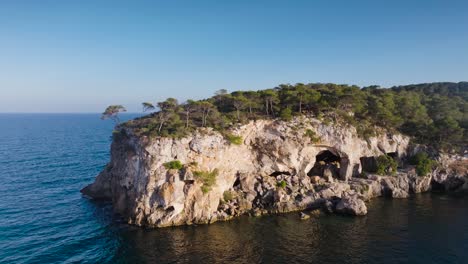 aerial - abandoned cave system in coastal limestone cliff, mallorca