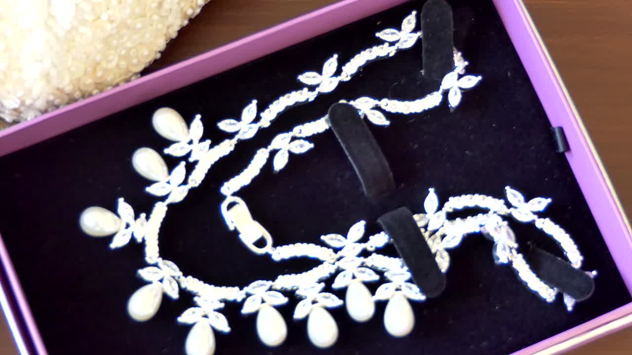 여자 지갑, 핸드백, 목걸이, 귀고리, 웨딩 액세서리의 클로즈업 샷