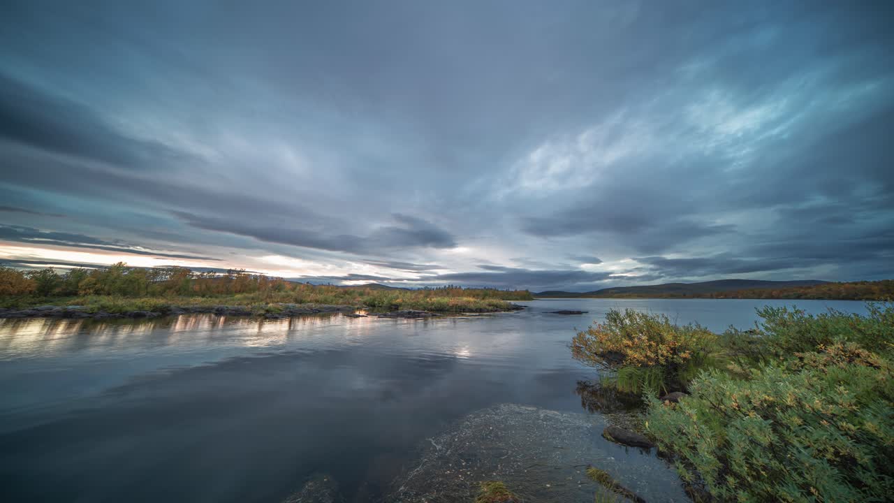 a medida que la oscuridad desciende sobre el paisaje, las nubes tormentosas se mueven rápidamente en los cielos del atardecer