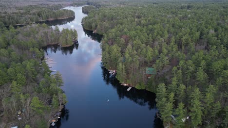 Luftaufnahme-Einer-Person,-Die-Auf-Einem-Ruhigen-Fluss-Kanu-Fährt,-Der-Sich-Durch-Einen-Dichten-Wald-Schlängelt,-Umgeben-Von-üppigem-Grün-Und-Natürlicher-Schönheit