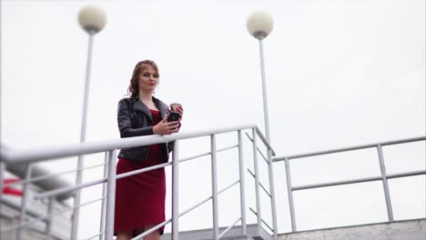 woman in red dress and black jacket on stairs