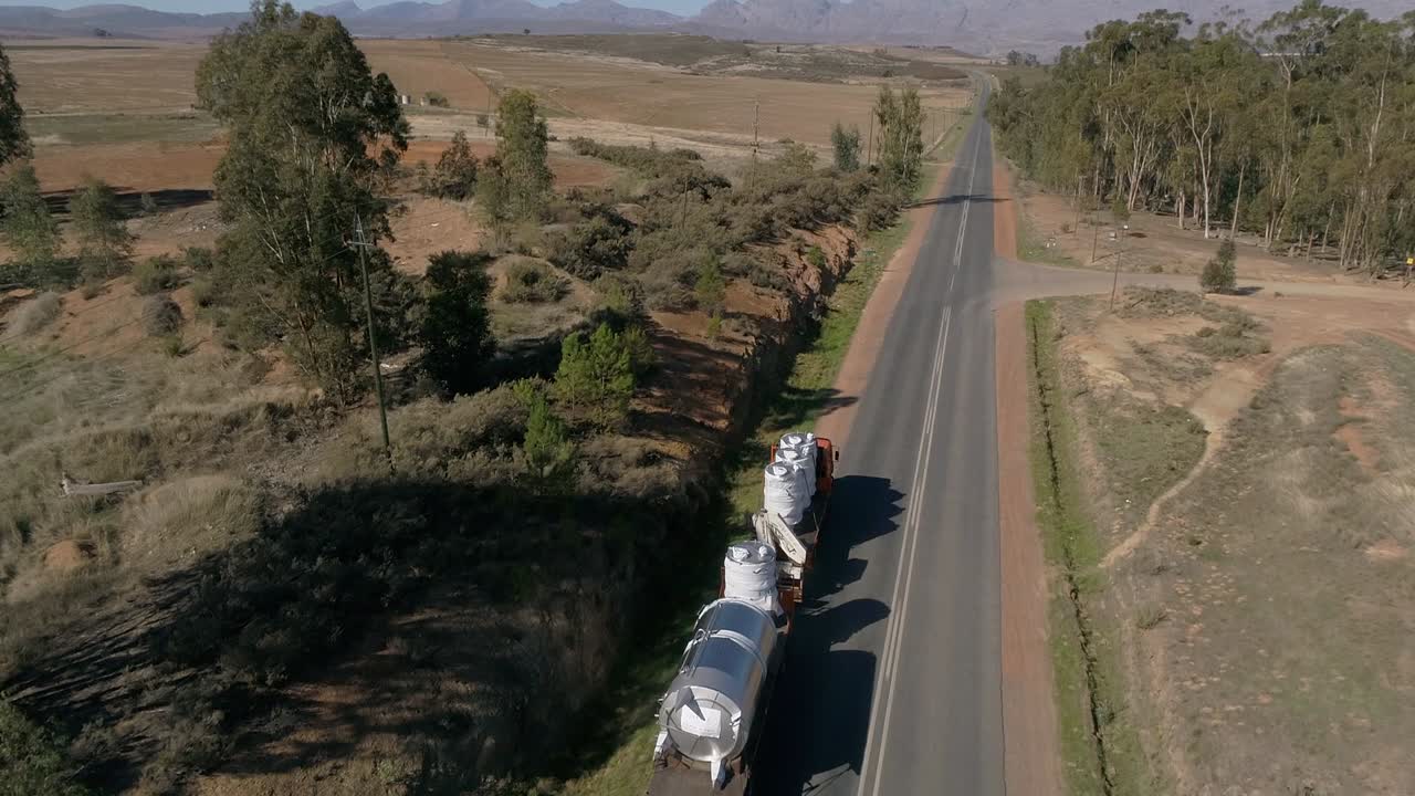 Ripresa aerea di un camion da trasporto commerciale che sorpassa su un'autostrada rurale in Sudafrica.