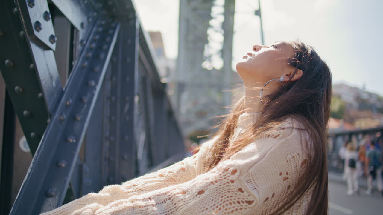 Seductive lady standing bridge putting face under sun closeup. Woman portrait