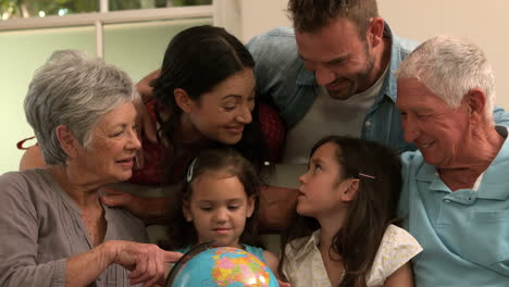 Multi-generation-family-on-the-sofa-looking-at-globe